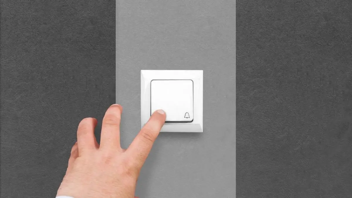 hand pressing a wireless doorbell button